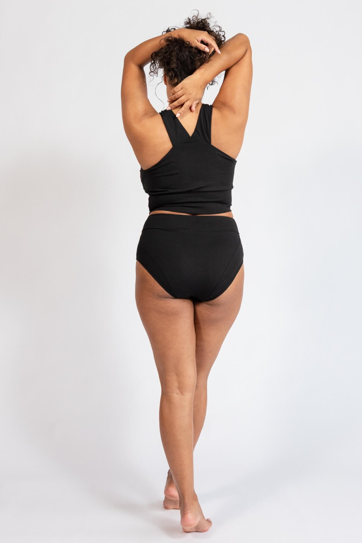 Person wearing a black underwear set on a white background