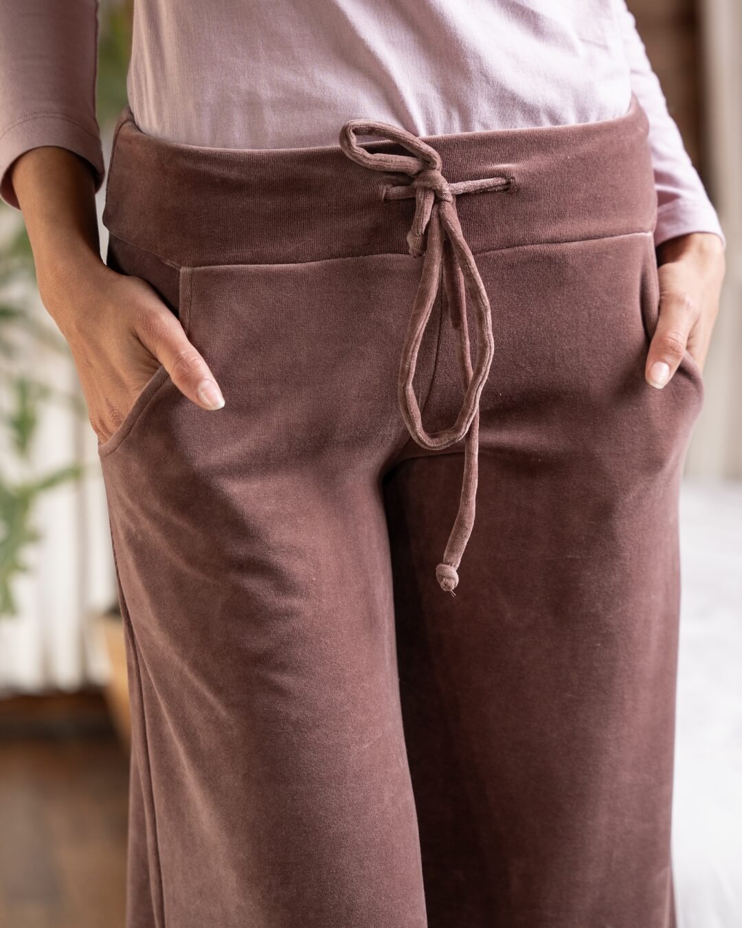 Cropped in pair of velvet pants on model. Model has her hands in the pockets and the drawstring is tied in a bow. 